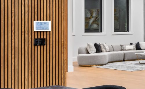 cheerful businesspeople laughing while standing under air conditioner in office